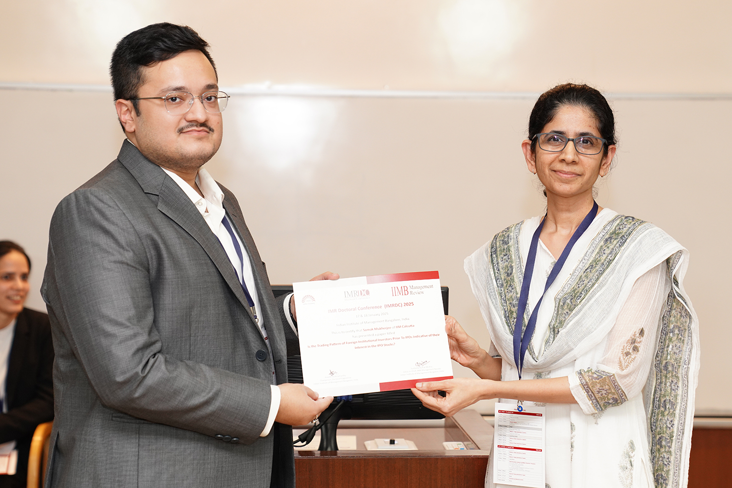Presentation of the IMRDC 2025 Best Paper Award to the winning research scholar at IIM Bangalore.