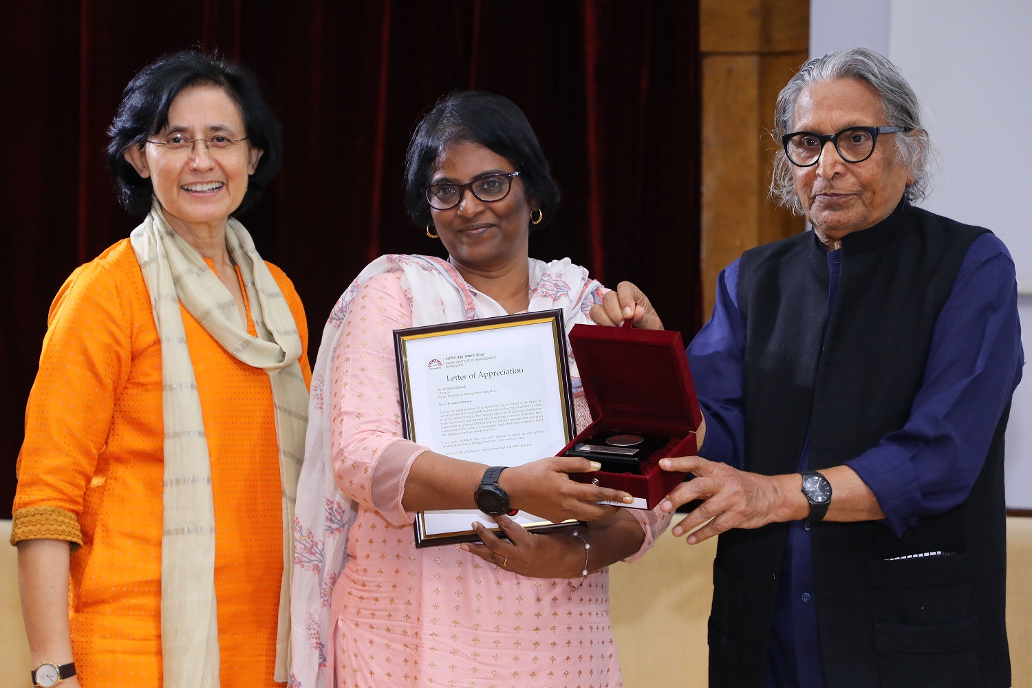 Dr. Rama Patnaik K., Librarian, receives 10 years’ Service award from Ms. Vinita Bali, Member, Board of Governors, IIMB, and Pritzker Laureate Dr. Balkrishna Doshi, on the occasion of IIMB’s 46th Foundation Day celebrations.