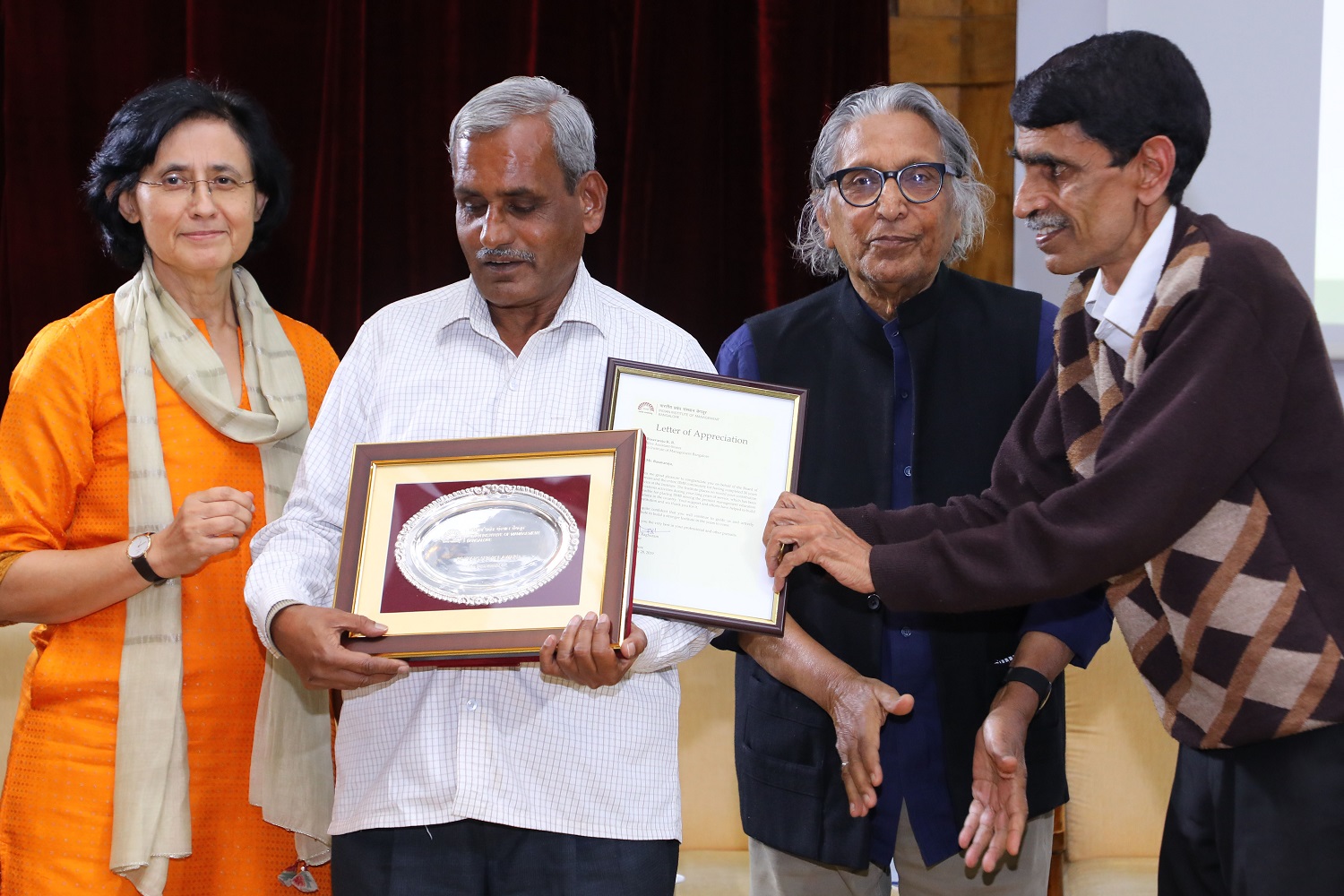 Basavaraju K.R., Stores Department, receives 30 years’ Service award from Ms. Vinita Bali, Member, Board of Governors, IIMB, and Pritzker Laureate Dr. Balkrishna Doshi, on the occasion of IIMB’s 46th Foundation Day celebrations.