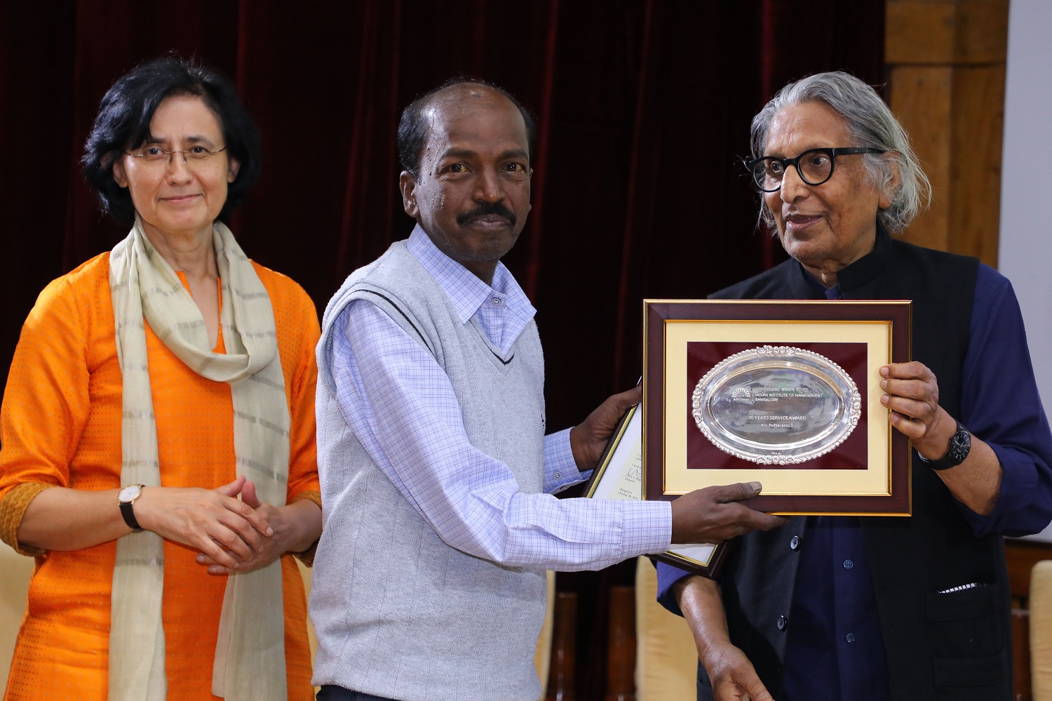 Puttaramu S., Senior Executive, receives 30 years’ Service award from Ms. Vinita Bali, Member, Board of Governors, IIMB, and Pritzker Laureate Dr. Balkrishna Doshi, on the occasion of IIMB’s 46th Foundation Day celebrations.