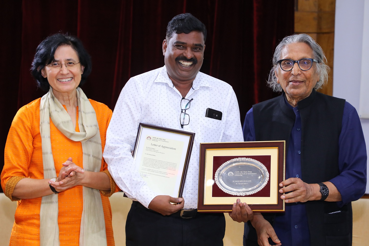 Ramesh Babu L., Administrative Officer, Executive Education Programmes, receives 30 years’ Service award from Ms. Vinita Bali, Member, Board of Governors, IIMB, and Pritzker Laureate Dr. Balkrishna Doshi, on the occasion of IIMB’s 46th Foundation Day celebrations.
