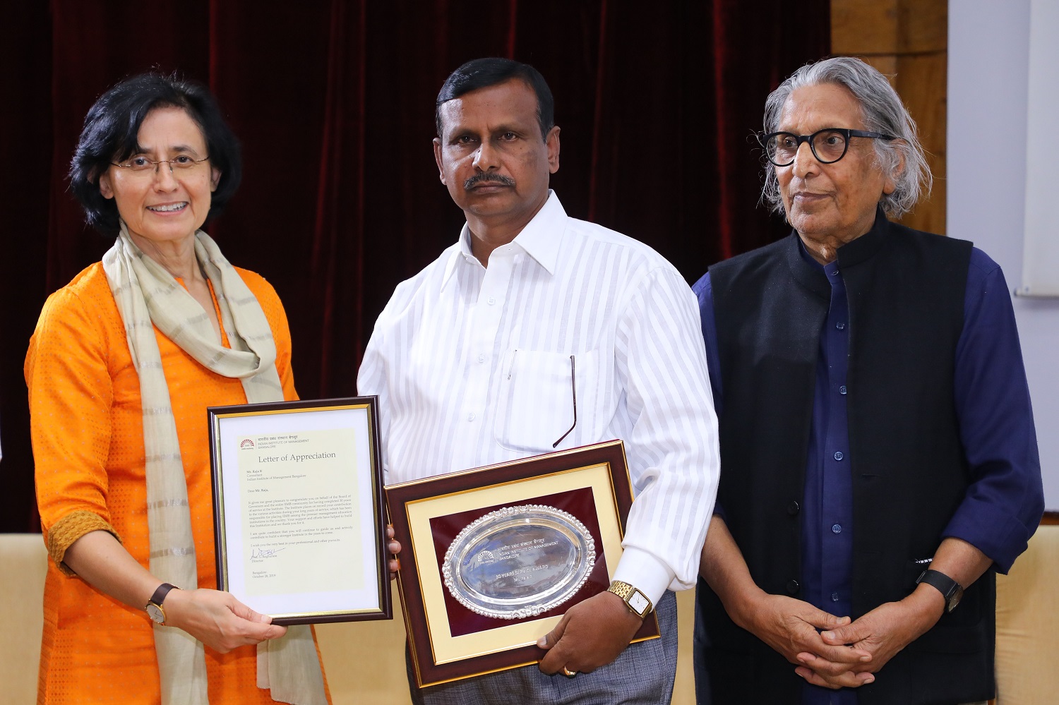 Raja R., Office of the Chief Administrative Officer, receives 30 years’ Service award from Ms. Vinita Bali, Member, Board of Governors, IIMB, and Pritzker Laureate Dr. Balkrishna Doshi, on the occasion of IIMB’s 46th Foundation Day celebrations.