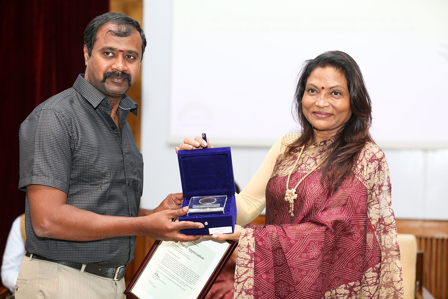 Mr Harsha Kumar B, Senior Accounts Executive, Accounts Department, receives the award for 10 years of service from Ms. Kalpana Saroj, Member of the Board of Governors, IIMB, during the institute’s 49th Foundation Day celebrations.