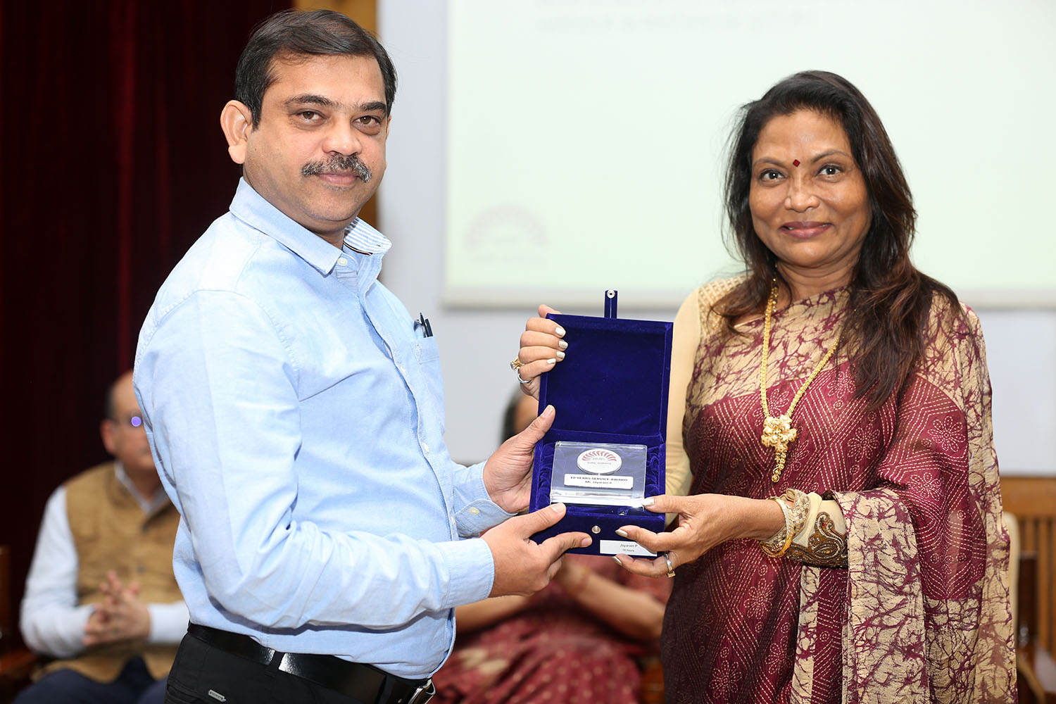 Mr Jayaram P, Assistant Manager, Computer Centre, receives the award for 10 years of service from Ms. Kalpana Saroj, Member of the Board of Governors, IIMB, during the institute’s 49th Foundation Day celebrations.