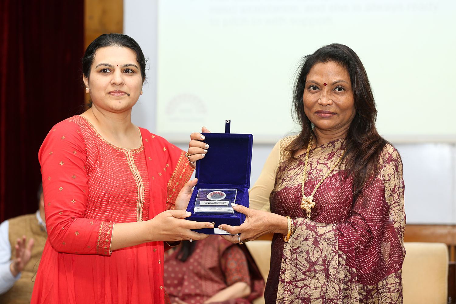 Ms Khushboo Chhangani, Coordinator, Office of Disability Services, receives the award for 10 years of service from Ms. Kalpana Saroj, Member of the Board of Governors, IIMB, during the institute’s 49th Foundation Day celebrations.
