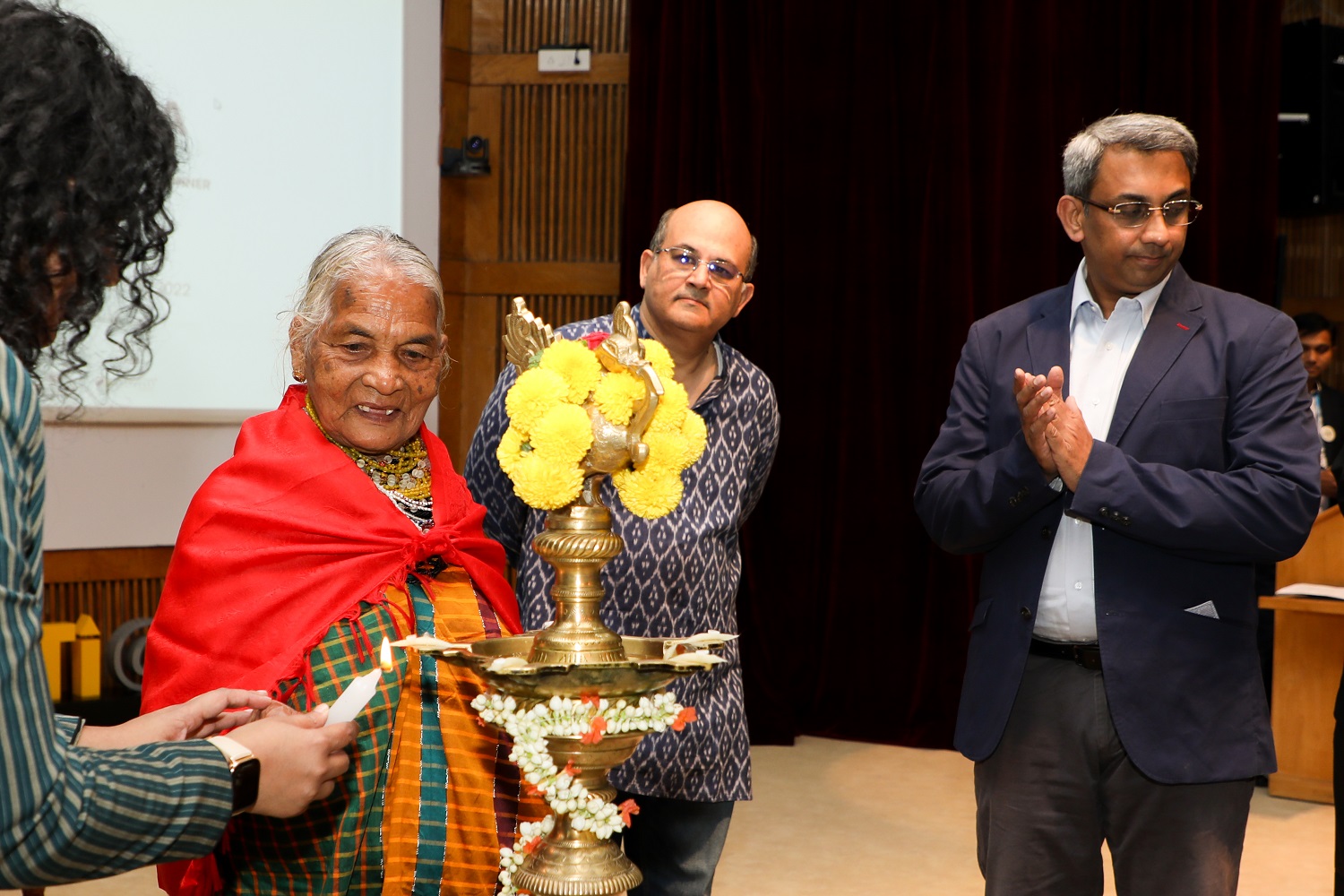 The ceremonial lamp is lit by Smt Tulsi Gowda. IIMB Director Professor Rishikesha T Krishnan, Professor Allen P Ugargol, Chairperson, PGPEM, and Ms Shreyas Seethapathy,  President, Student Affairs Council, PGPEM, look on.