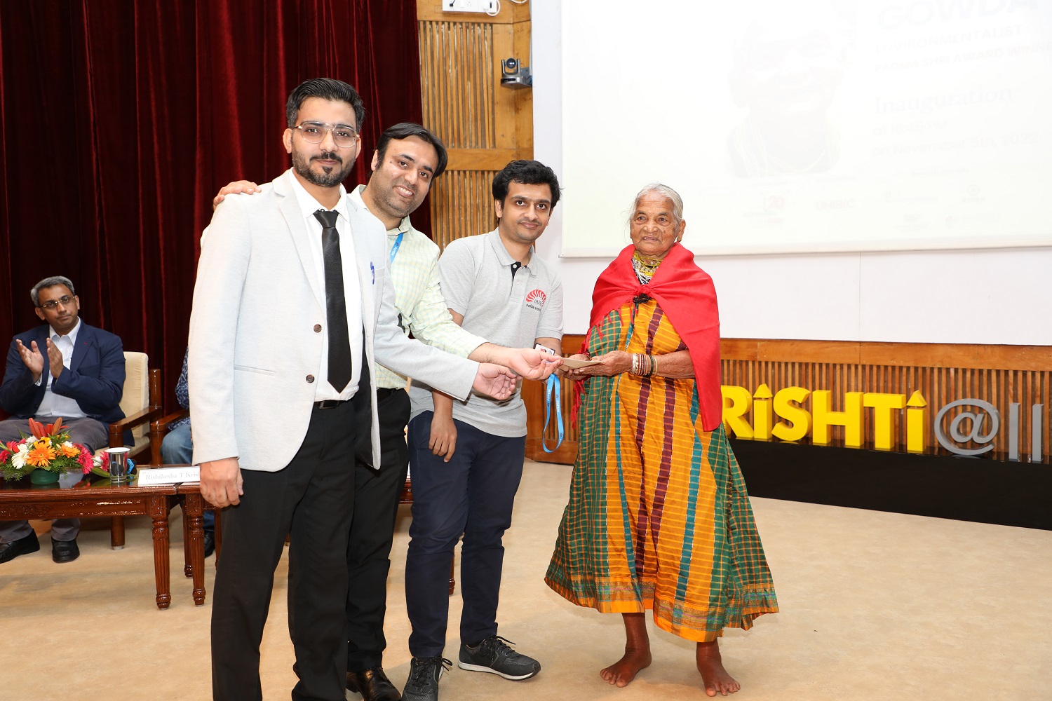 First-year PGPEM students Javed, Abhinav and Vipin receive an award from Smt Tulsi Gowda.