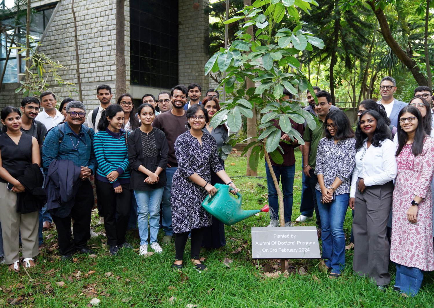 The incoming PhD scholars water a tree planted by alumni of the PhD Programme, symbolizing the continuity of knowledge, growth, and the enduring legacy of the research community at IIM Bangalore.