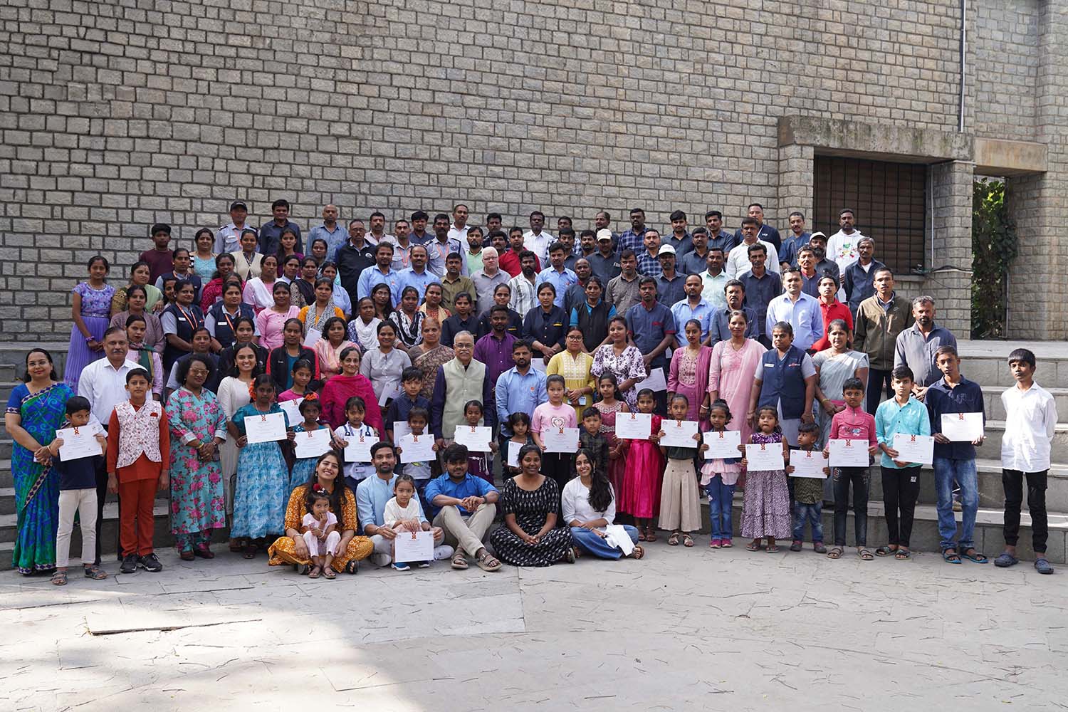 A group photograph of faculty members, Deans, Vikasana team members, non-teaching staff, and their children who received the scholarship.