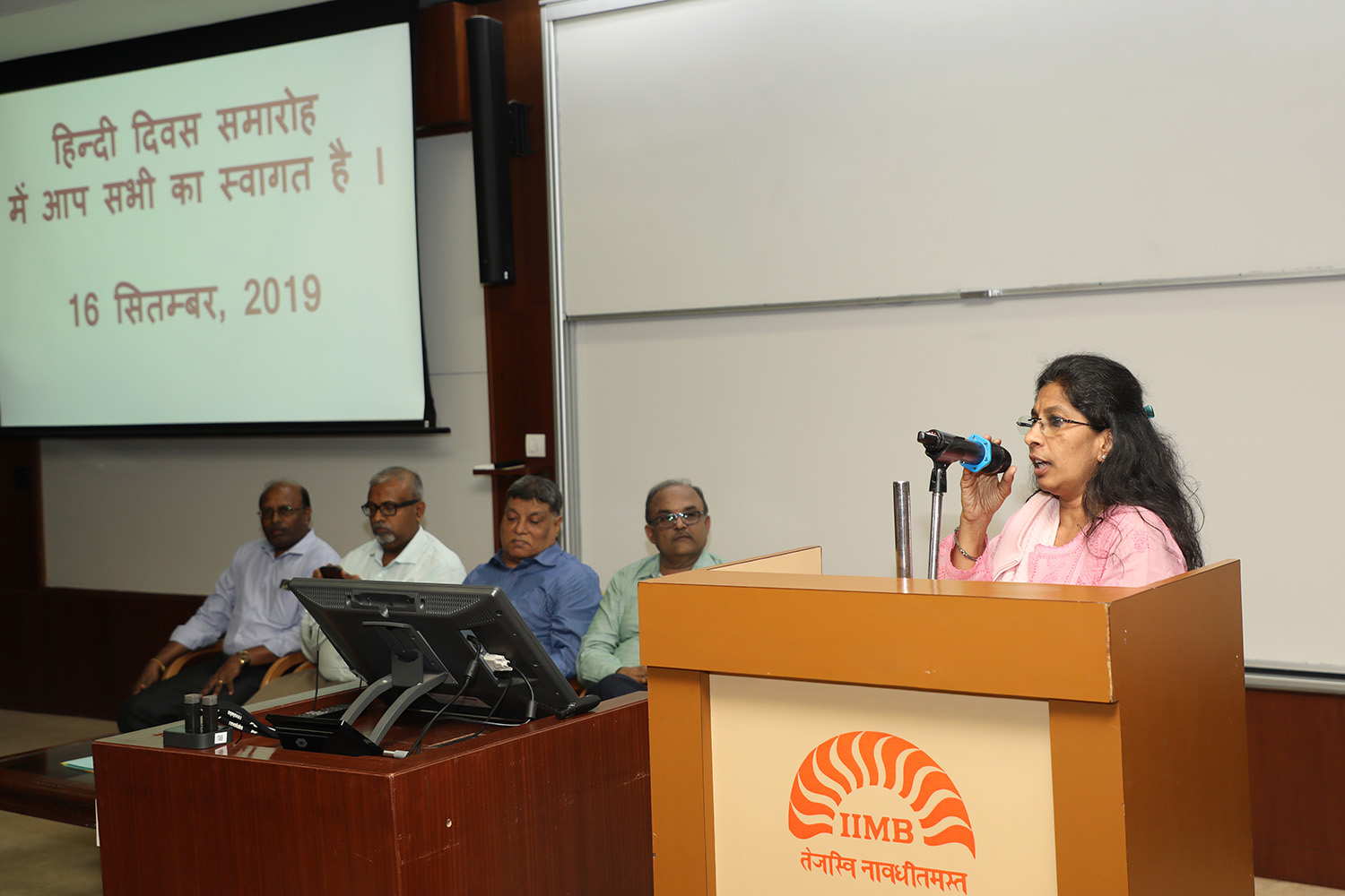 Neetha John, Hindi Officer, IIMB, reads out a message from Dr. Ramesh Pokhriyal, Union Minister of Human Resource Development.