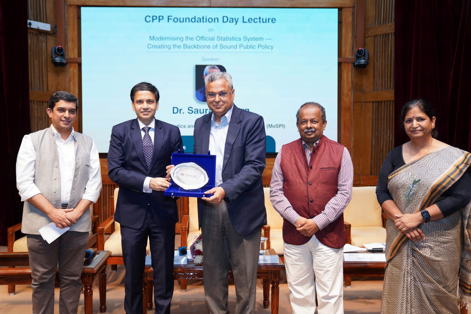 (L-R): Prof. Arnab Mukherji, Chairperson, PGPPM; Prof. Sourav Mukherji, Dean, Faculty, IIM Bangalore; Dr. Saurabh Garg, Secretary, Ministry of Statistics and Programme Implementation; Prof. Gopal Naik, Senior Fellow, Public Policy area; and Dr. Anjana Dube, Chief Policy Officer, Centre for Public Policy, at the Centre's Eighth Foundation Day Lecture, held on 09 July 2026 at IIM Bangalore to mark the Centre's 26th Foundation Day. Dr. Saurabh Garg receives the memento from Prof. Sourav Mukherji.