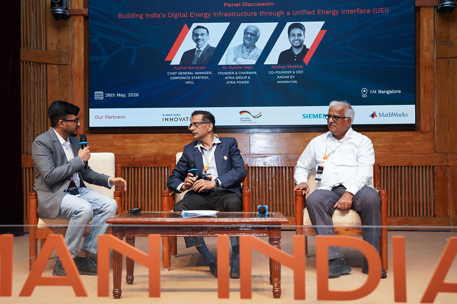 (L-R): Moderator Akshay Shekhar, Co-founder, Kazam Energy; Kushal Banerjee, Chief General Manager, Corporate Strategy, HPCL and Dr. Sunder Raju, Founder and Chairman, Atria Group & Atria Power, during a panel discussion on, ‘Building India’s Digital Energy Infrastructure through a Unified Energy Interface’, at the German Indian Mobility Summit 2026 at IIM Bangalore, on 26th May 2026.