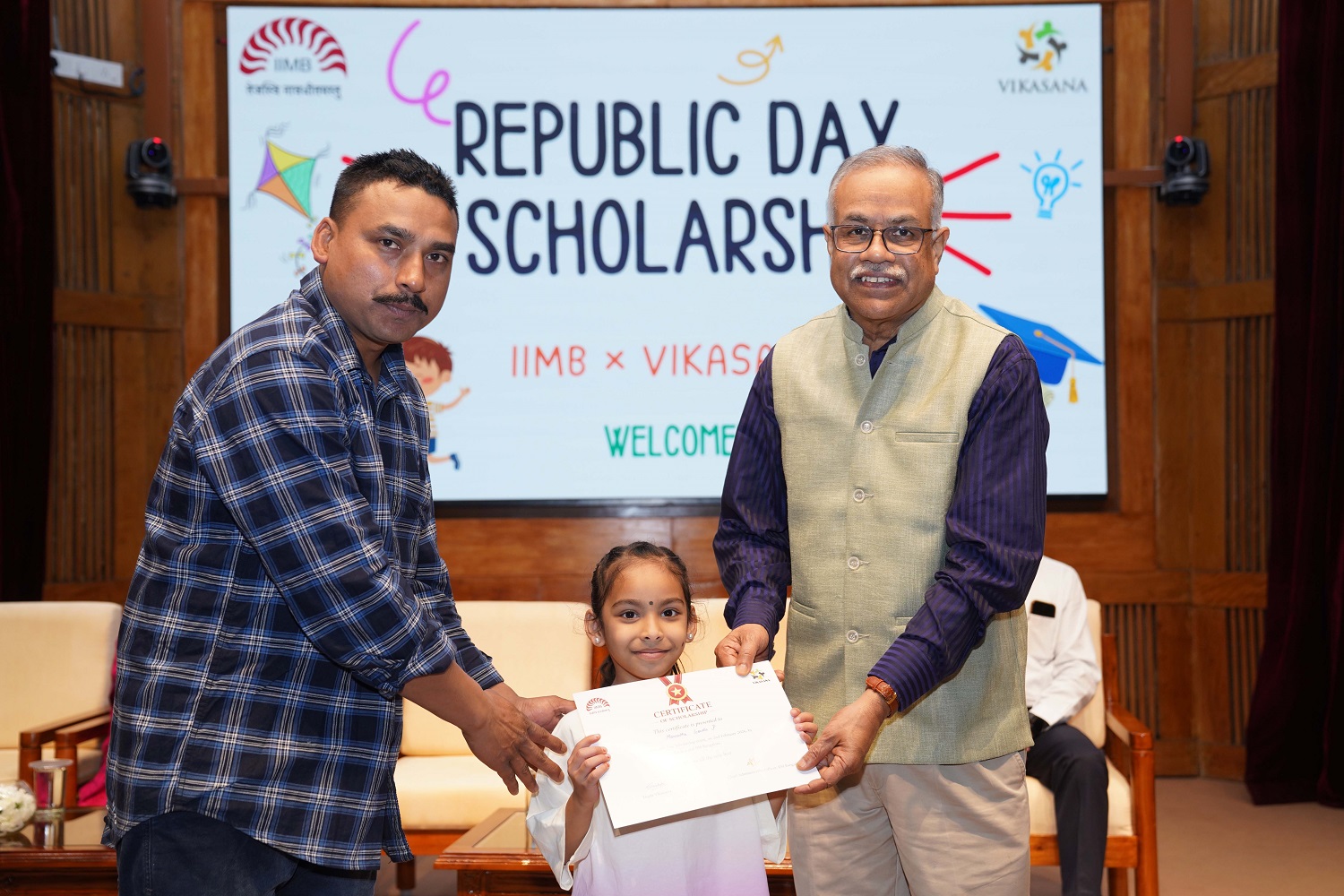 Prof. M. Jayadev, Dean, Administration, distributing a scholarship certificate to a student.