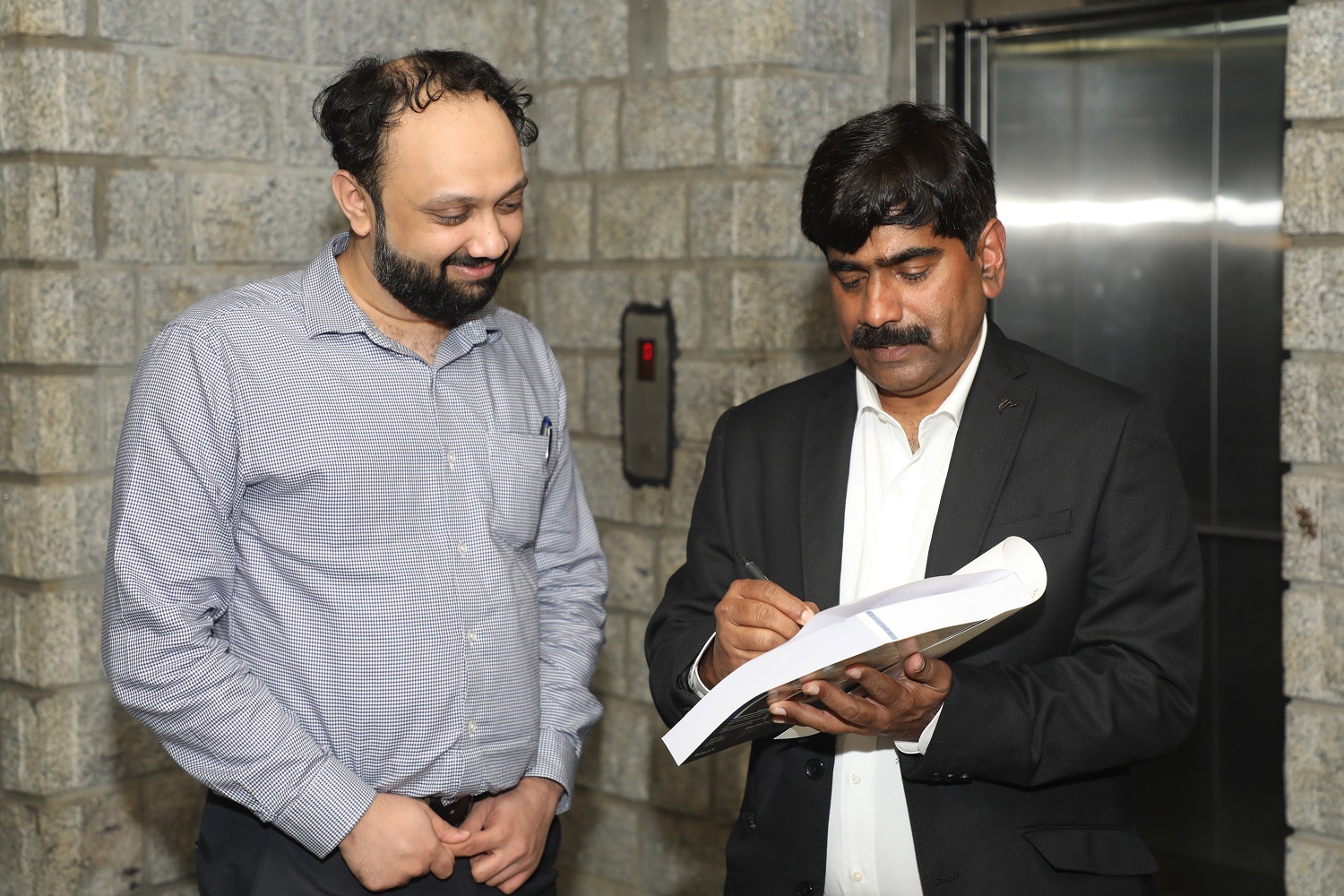 Prof. U Dinesh Kumar, Co-Author, Machine Learning Using R’ and  ‘Data Visualization’ signs a copy of the book during the book launch event.